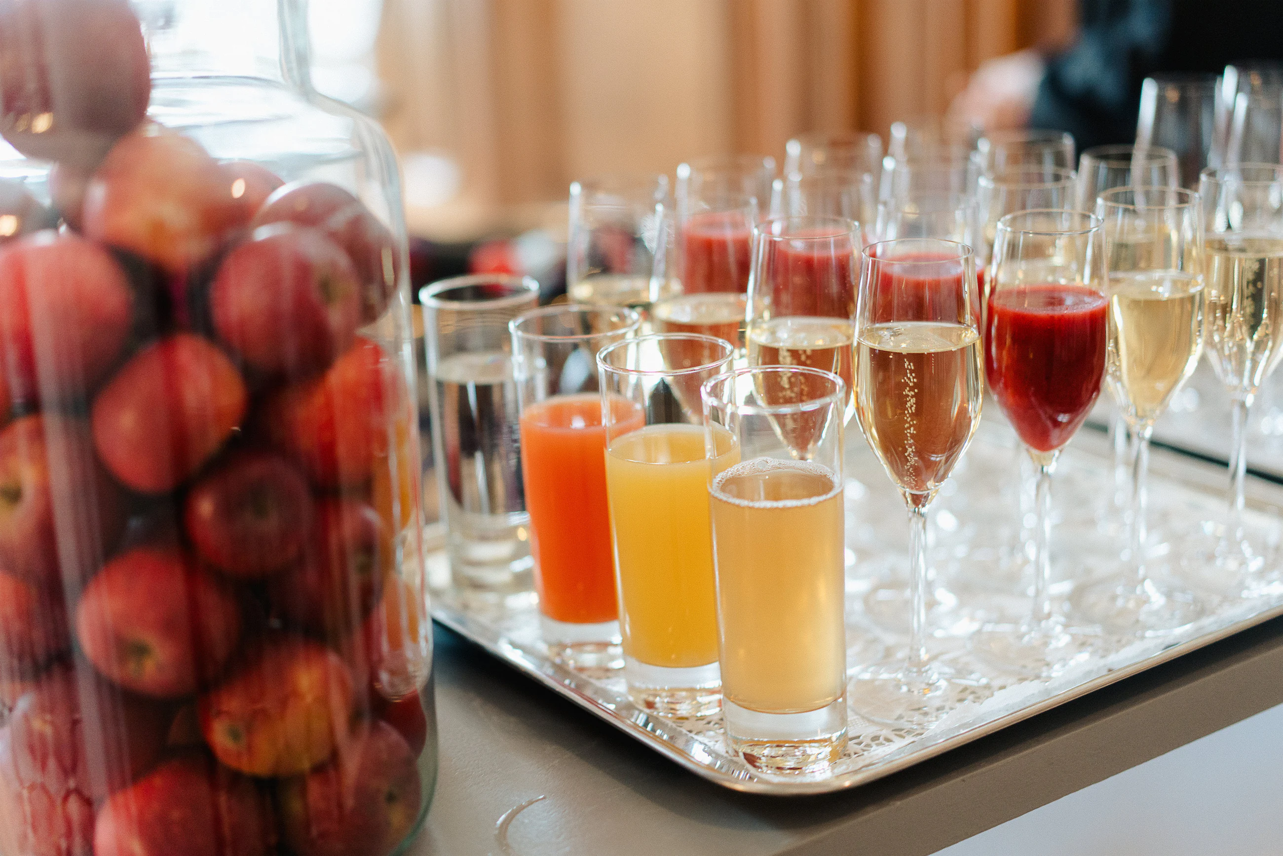 Plateau de verres à cocktail colorés et bocal de fruits rouges sur un comptoir