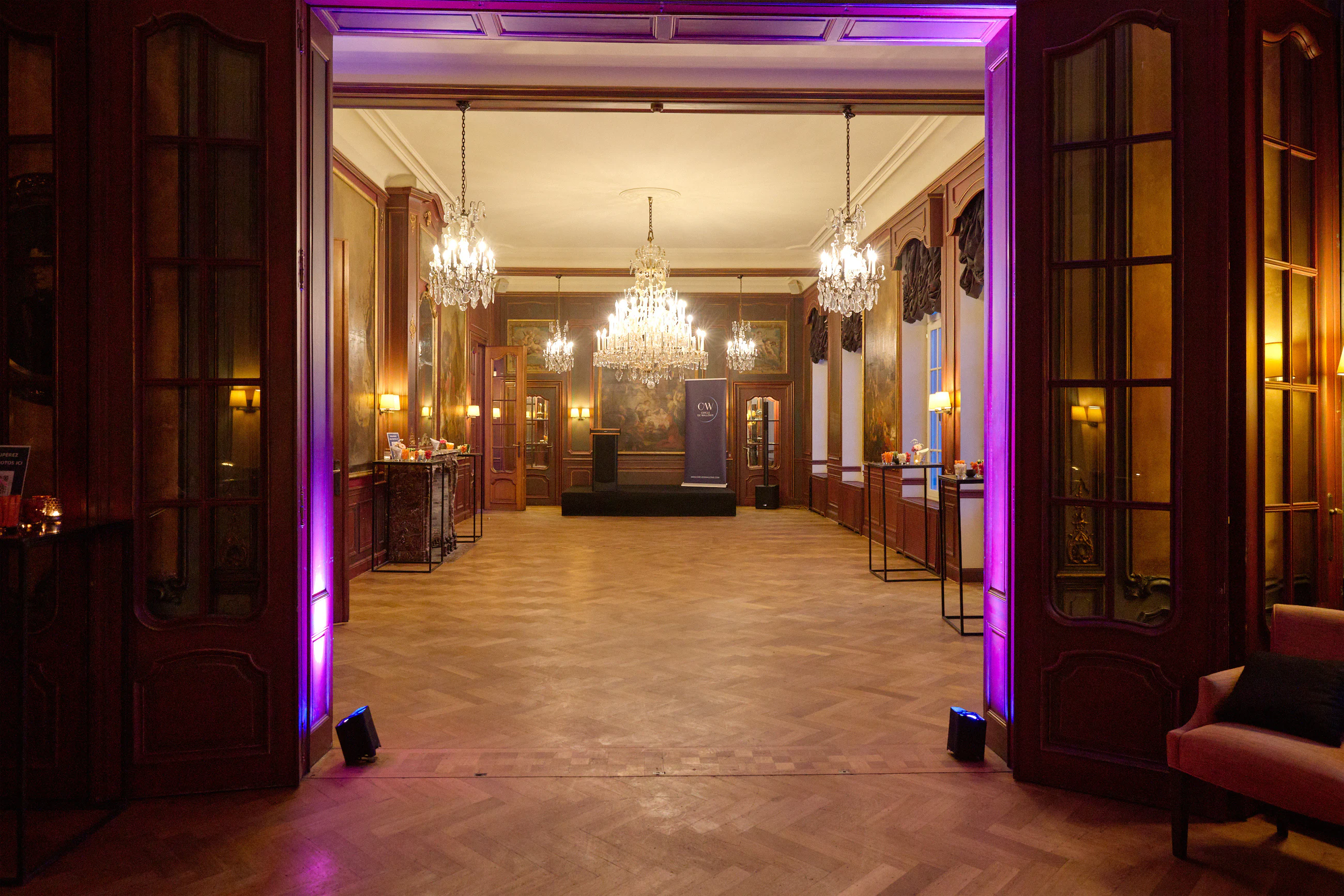 Entrée éclairée d'un bâtiment élégant avec lumières violettes et sol en pierre