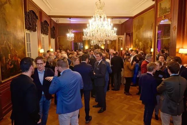 Réception élégante dans une salle ornée avec lustre et invités