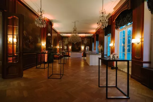 Salle spacieuse avec vitrines d'exposition, éclairage chaud et boiseries sombres.